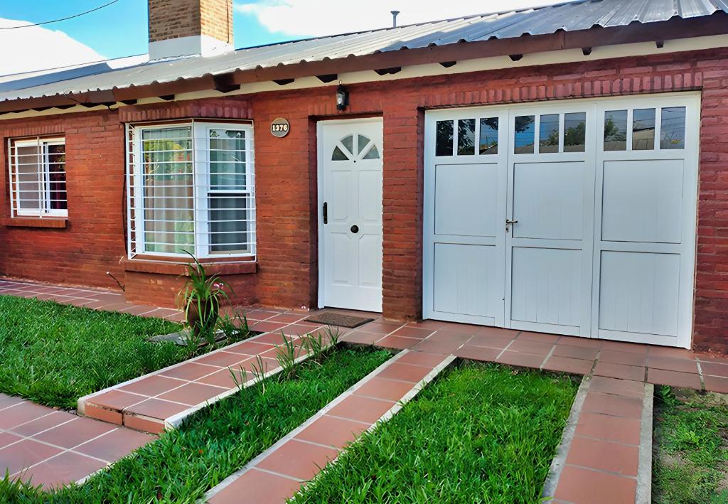 una casa de ladrillo rojo con dos puertas blancas de garaje en Magnolia azul en Federación