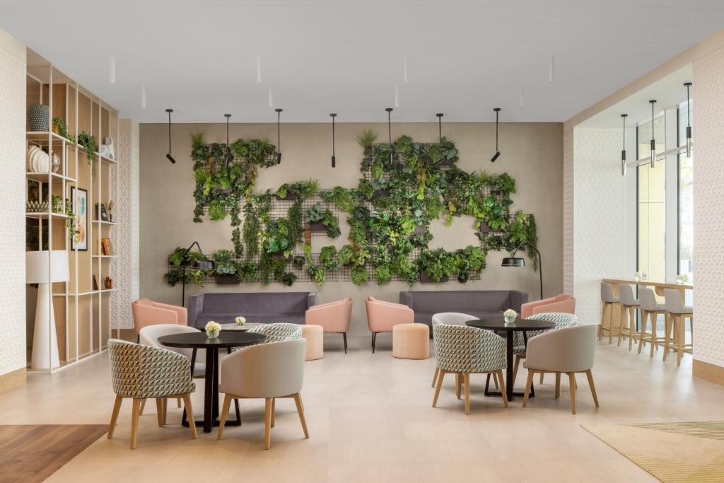 uma sala com mesas e cadeiras e uma parede de plantas em Holiday Inn Dubai Business Bay, an IHG Hotel em Dubai