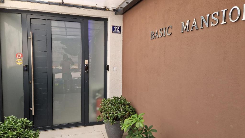 ein Gebäude mit einer Glastür und einem Schild darauf in der Unterkunft Basic Mansion Mandalina in Šibenik