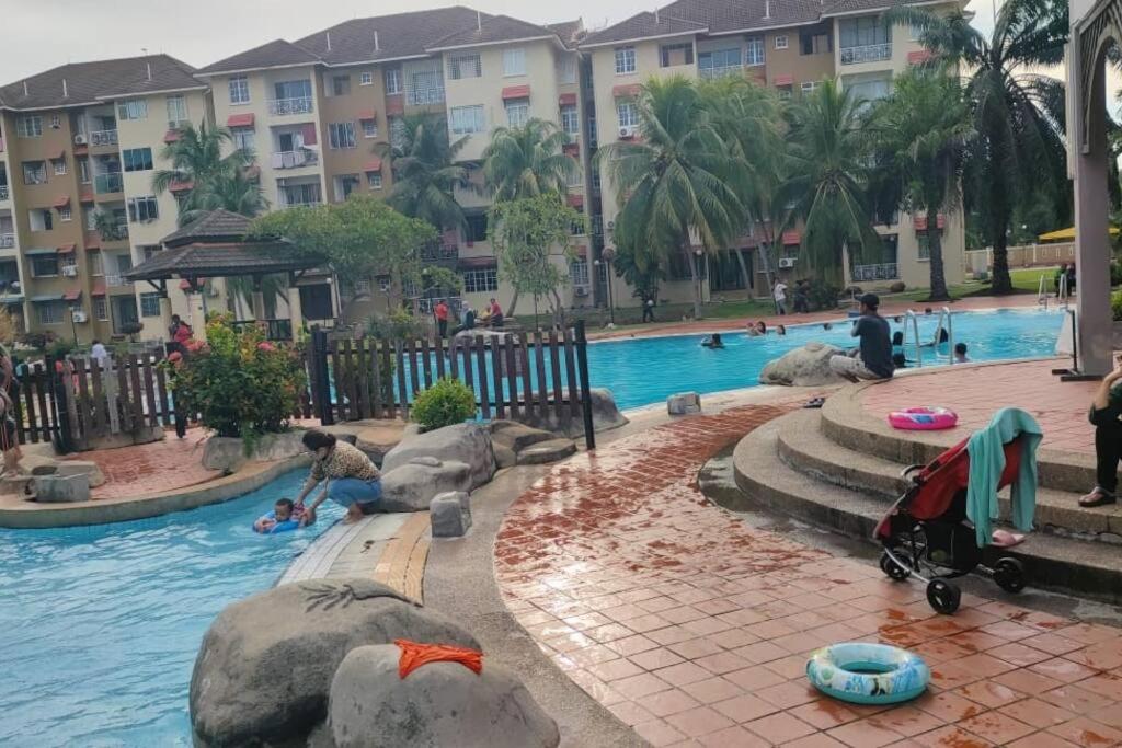 ポートディクソンにあるMilia Homestay PD Perdana Condoの水中で遊ぶ人々とリゾートのプールを利用できます。