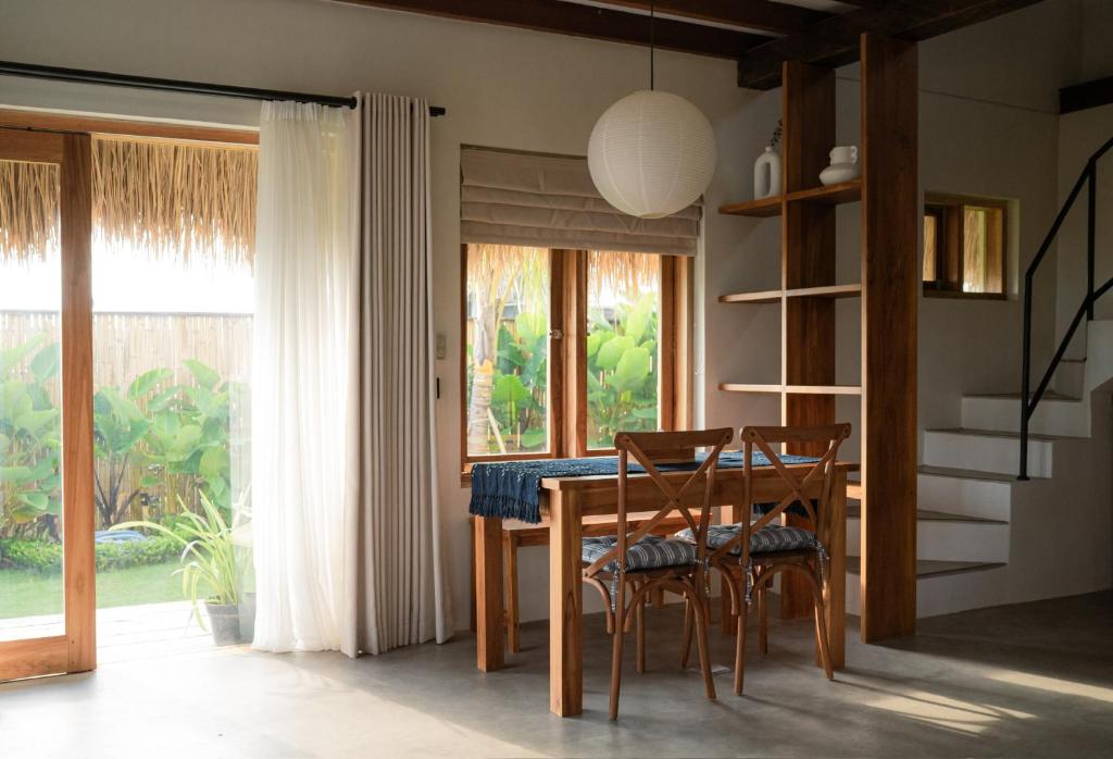 a dining room with a table and chairs and a window at Makai Medewi in Airsatang