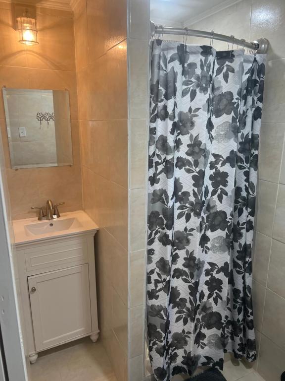 a bathroom with a shower with a black and white shower curtain at Gold Star in Plant City