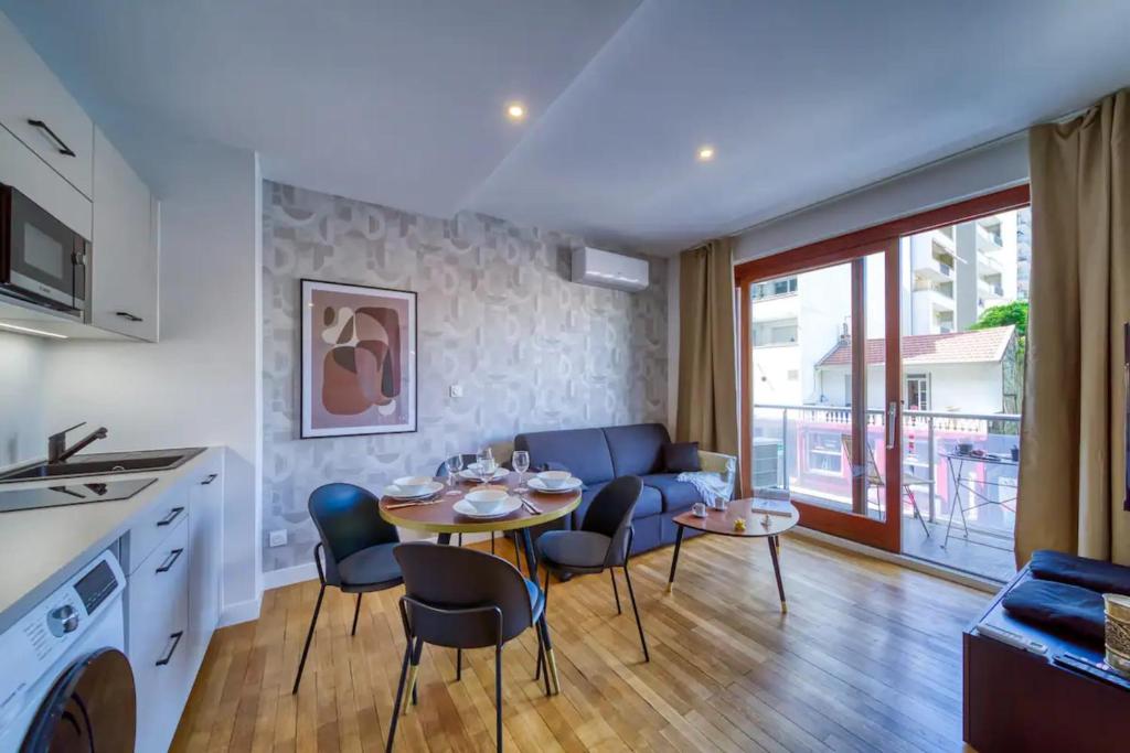 une cuisine et un salon avec une table et des chaises dans l'établissement #GQ Le Beau Mallifaud, à Grenoble