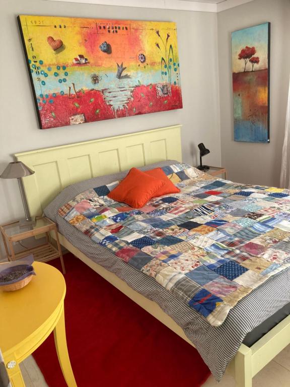 a bedroom with a bed with a quilt on it at Cozy ,artistic cottage in a garden setting close to the beach and hiking trails. in Powell River