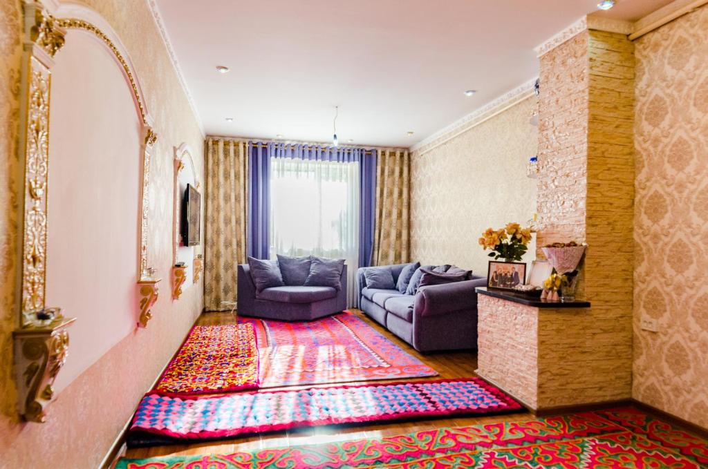 a living room with two couches and a rug at ilim-mahabat in Bishkek