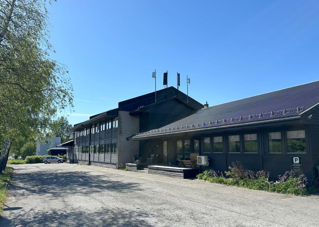 a building with a parking lot in front of it at Karivollen Overnatting in Melhus