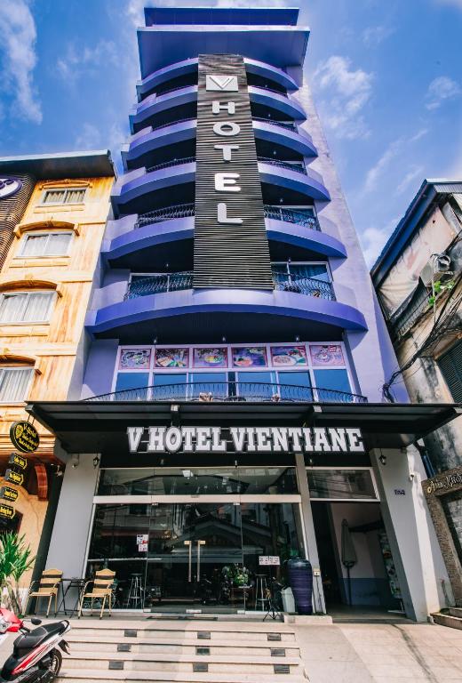a tall blue building with a hotel sign on it at V Hotel Vientiane in Vientiane
