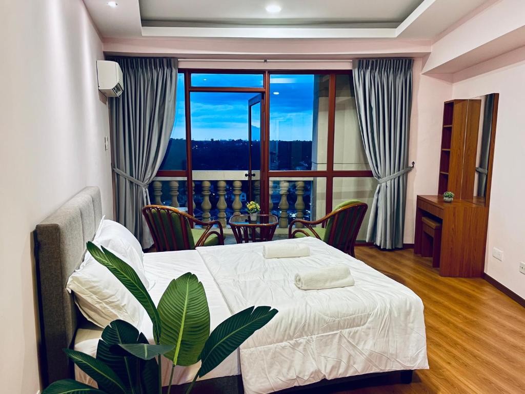 sypialnia z łóżkiem i dużym oknem w obiekcie Kuching City Center Riverbank Suites With Marvelous River View w mieście Kuching