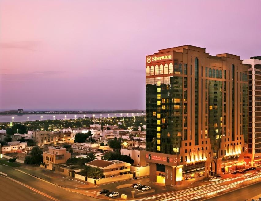 un gran edificio con luces encendidas en una ciudad en Sheraton Khalidiya Hotel en Abu Dabi