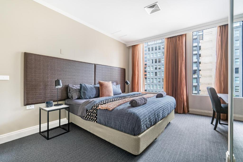 una camera con un grande letto e una grande finestra di Style and Convenience on Little Bourke a Melbourne