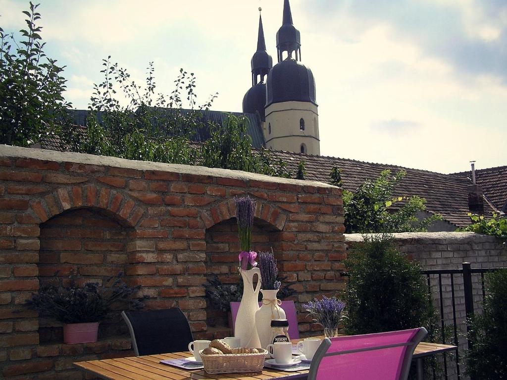 a table with chairs and a building in the background at Penzion Marriot in Trnava