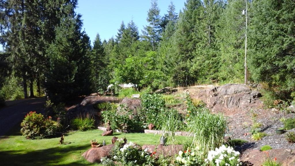 a garden with rocks and trees on a hill at Beaver Hut Bed And Breakfast in Port Alberni