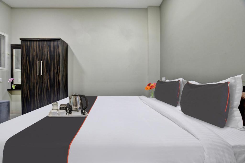 Cama blanca grande en habitación con puerta negra en Collection O Hotel Heritage en Indore