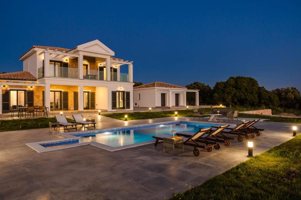 a villa with a swimming pool at night at The Ionian Sea & Sunset View Villa in Minia