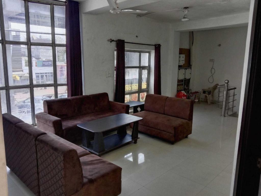 een woonkamer met 2 banken en een salontafel bij SPOT ON Hotel Deepak Palace in Amritsar