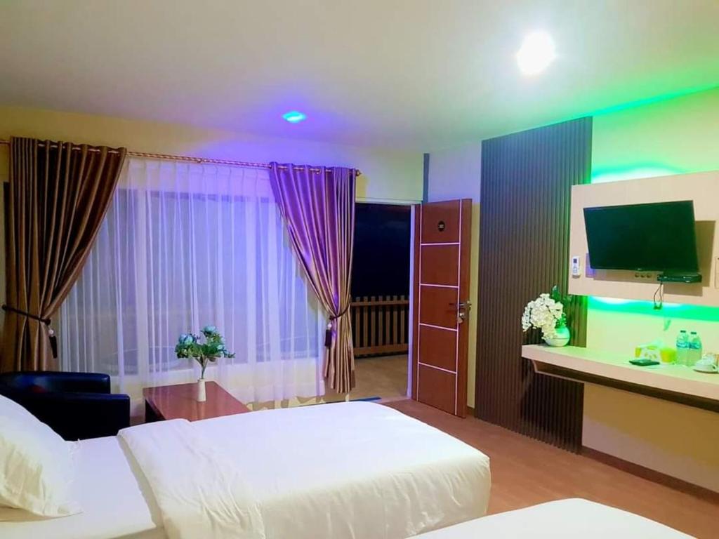 Pokój hotelowy z łóżkiem i biurkiem z telewizorem w obiekcie Jelita Beach Mentawai w mieście Tua Pejat