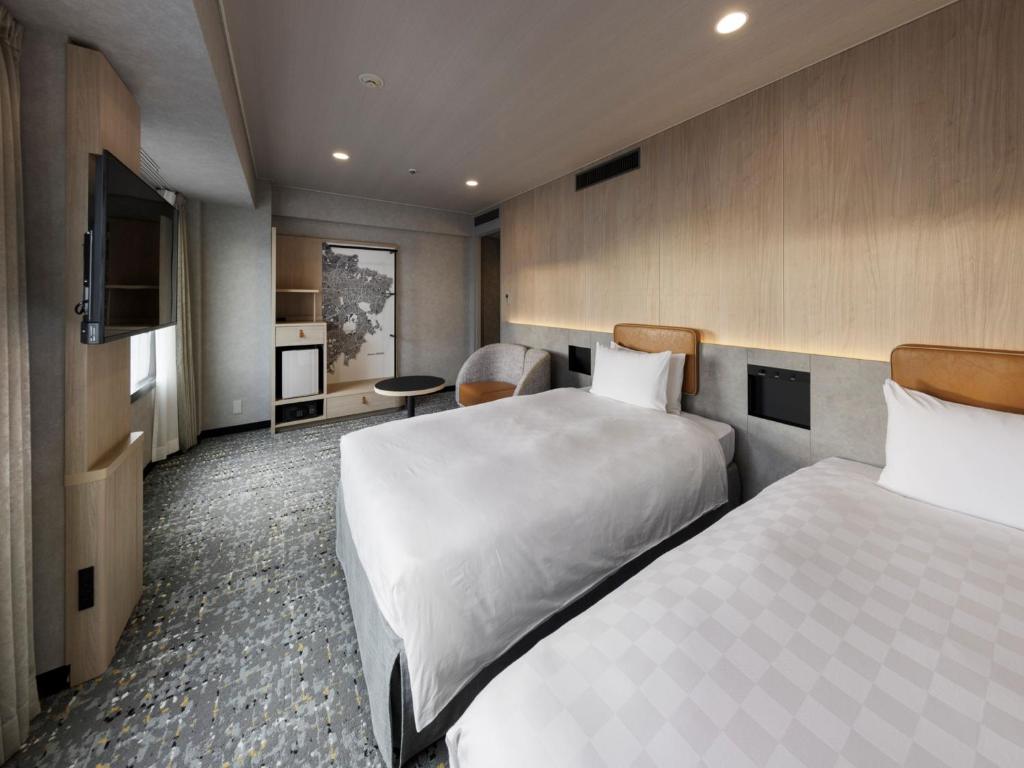 a hotel room with two beds and a television at Shinjuku Prince Hotel in Tokyo