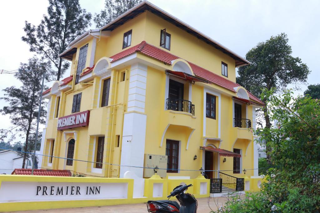 a motorcycle parked in front of a yellow building at Premier Inn in Yercaud