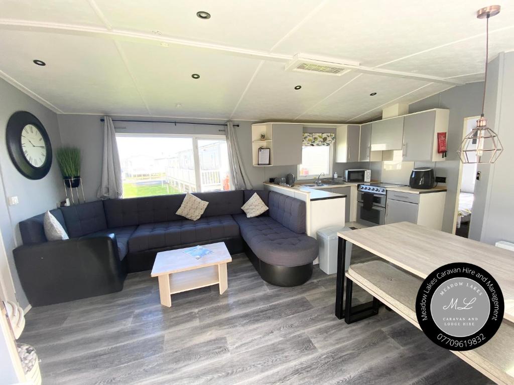 un salon avec un canapé et une table dans l'établissement Palm Grove 1 - Golden Palm Resort - Pet friendly, WiFi and Bed linen - Meadow Lakes Caravan & Lodge Hire, à Chapel St. Leonards