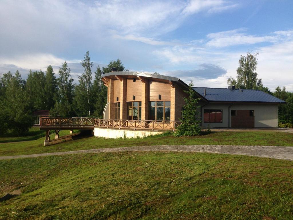 a small house with a bridge in front of a field at Atpūtas komplekss "Grantiņi" in Platone