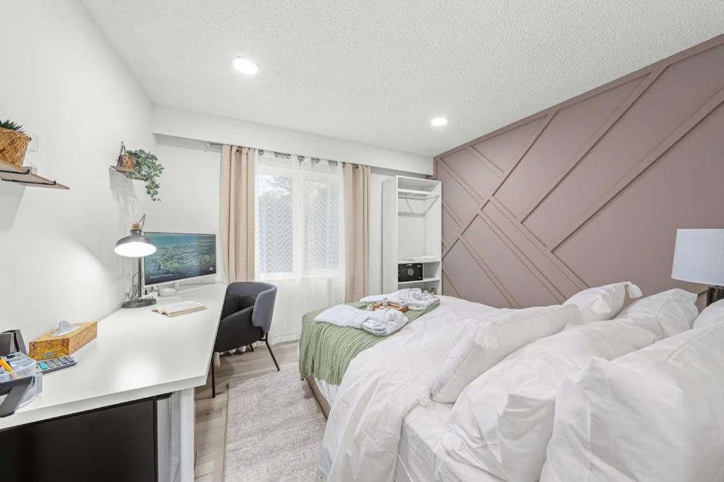a bedroom with a bed and a desk with a computer at North York, Smart Monitor, Private bath, Parking in Toronto