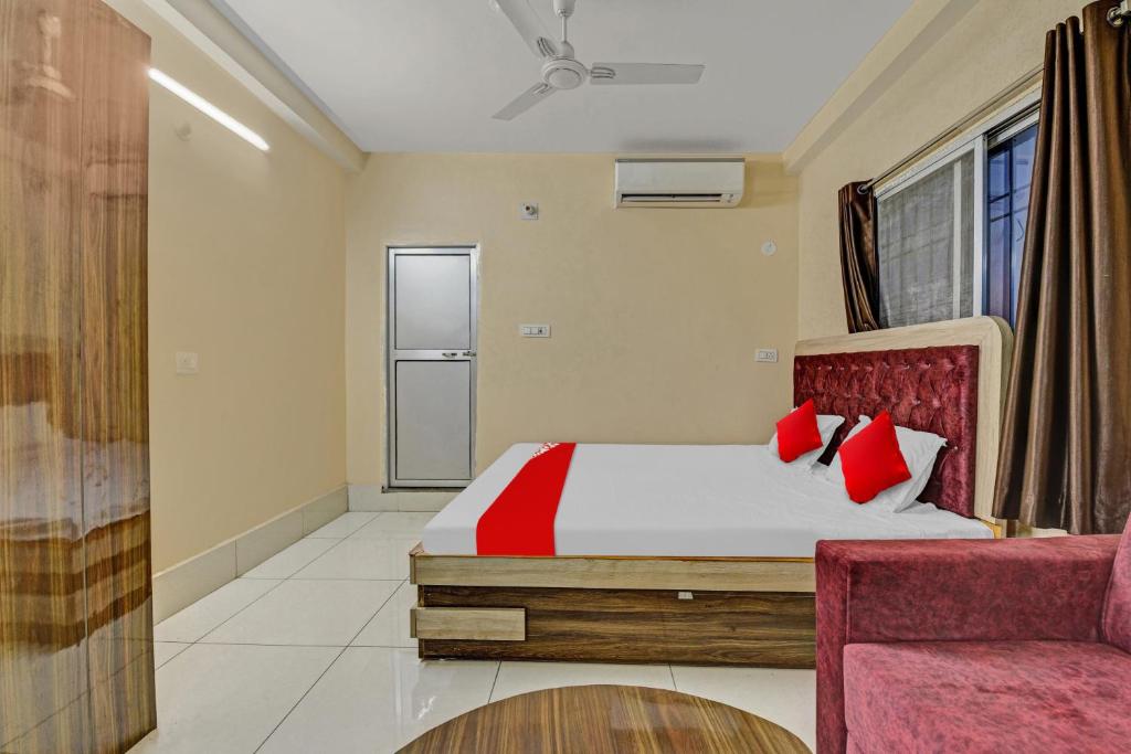 ein Schlafzimmer mit einem Bett mit roten Kissen und einem Stuhl in der Unterkunft OYO Flagship 81208 Jagarnath Palace in Ranchi