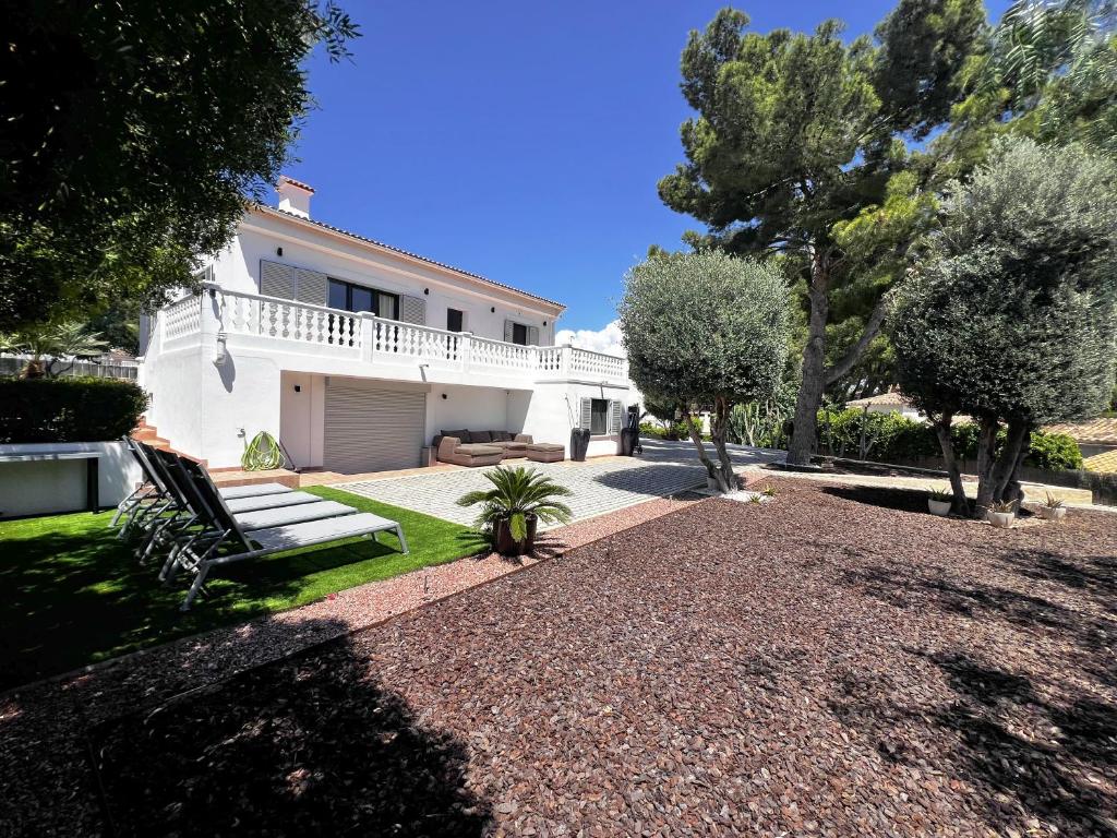 a white house with trees and a gravel driveway at Casa Goldberg in Paguera