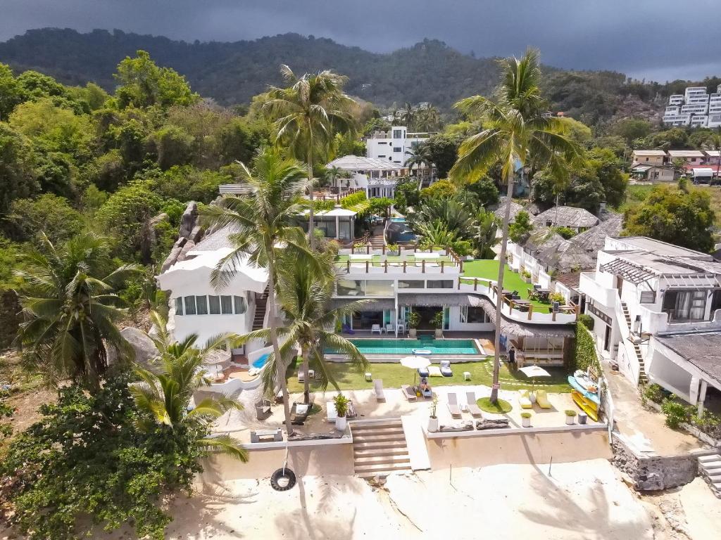an aerial view of a house with a swimming pool and palm trees at The Rock Samui Beachfront Resort - Sha Plus Hotel in Lamai