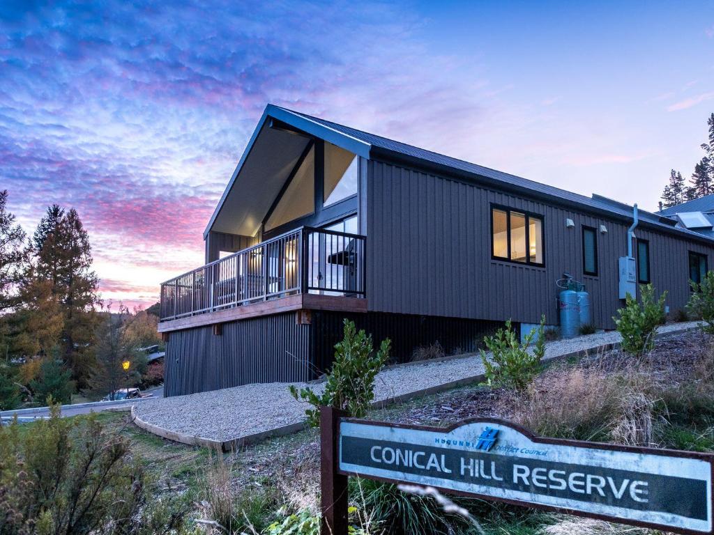 a house on a hill with a sign in front of it at Jacks Lodge Townhouse in Hanmer Springs