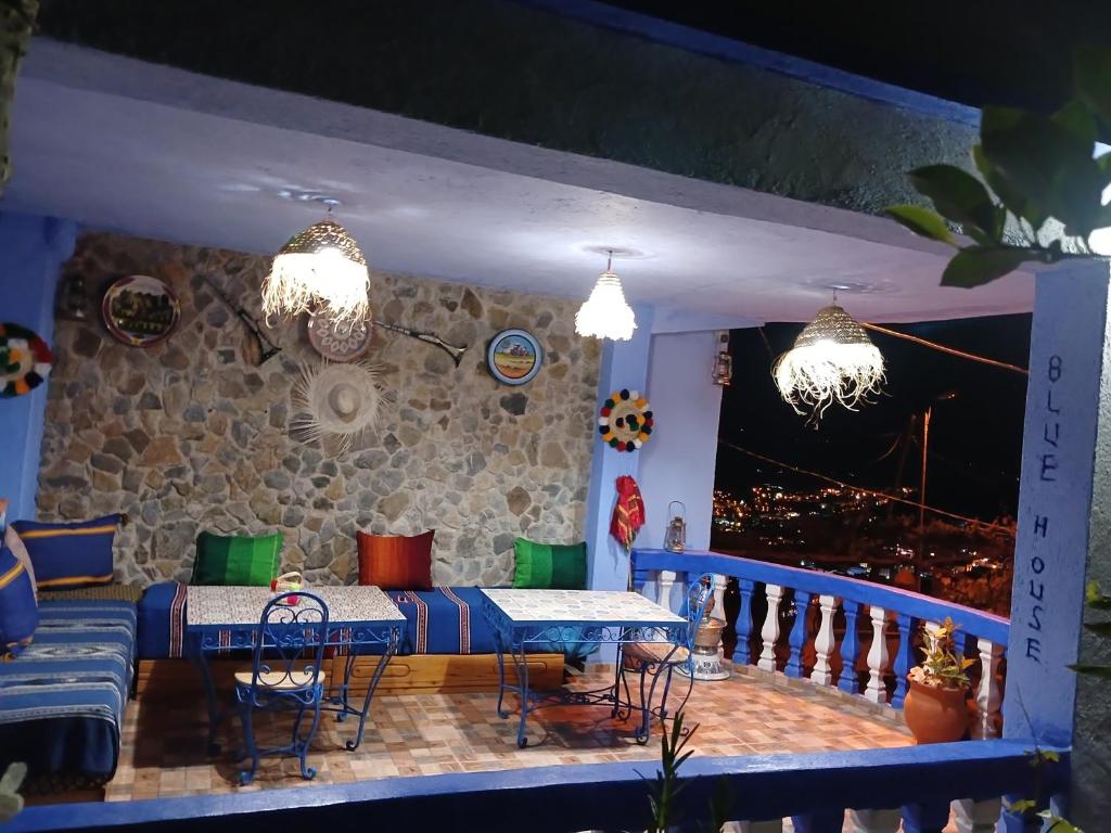 eine Terrasse mit einem Tisch und Stühlen auf dem Balkon in der Unterkunft Blue House Town in Chefchaouen