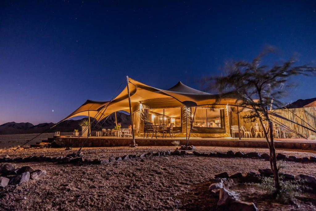 a tent in the middle of a desert at night at Desert Hills Glamping Camp in Sesriem