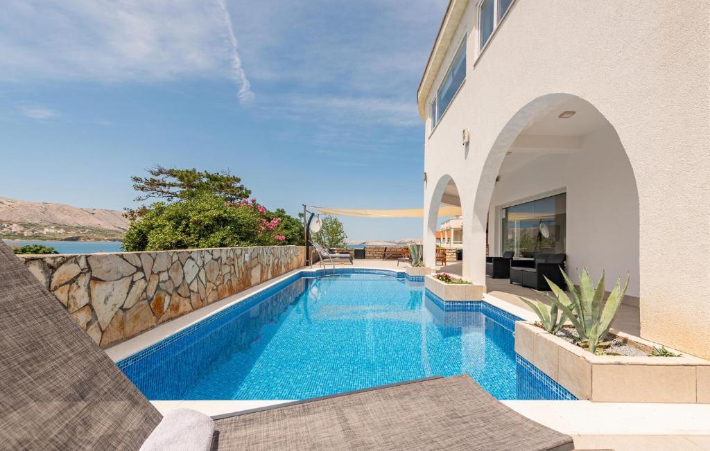 a swimming pool in front of a house at Luxurious Home In Pag in Pag