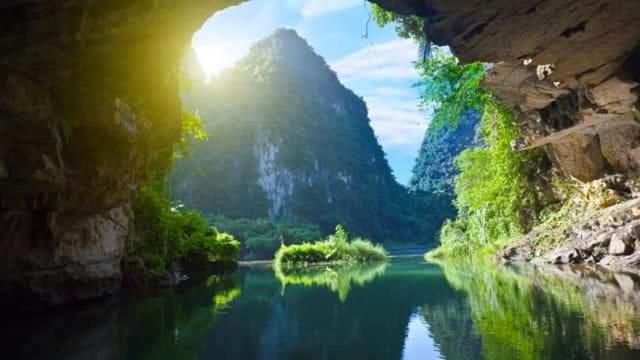 a view of a river with a mountain in the background at Tam Coc Paradise Homestay in Ninh Binh