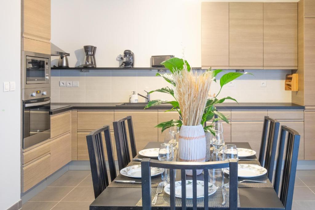a kitchen with a table with chairs and a vase at Printemps chaleureux T4 +2 place de parking privée in Annecy