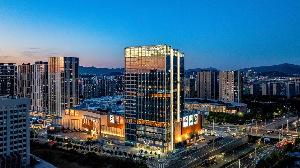 wysoki budynek w mieście w nocy w obiekcie EVEN Hotel Qingdao Laoshan - an IHG Hotel w mieście Qingdao