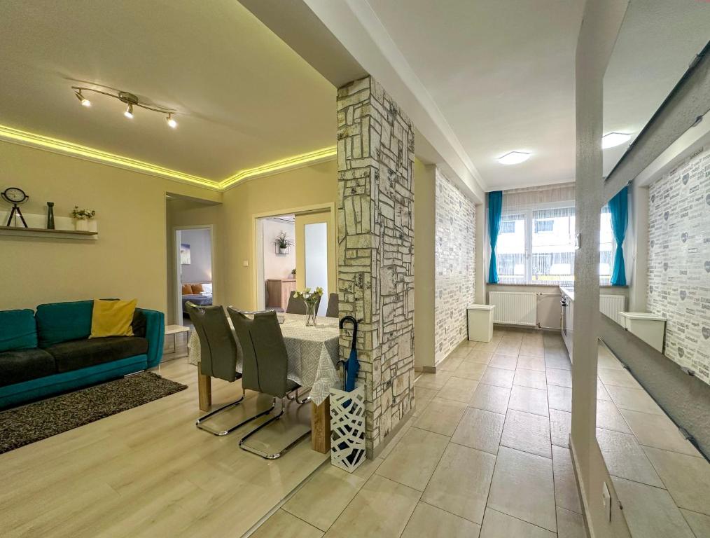 een woonkamer met een blauwe bank en een stenen open haard bij Asbóth Taylor Apartment in Boedapest
