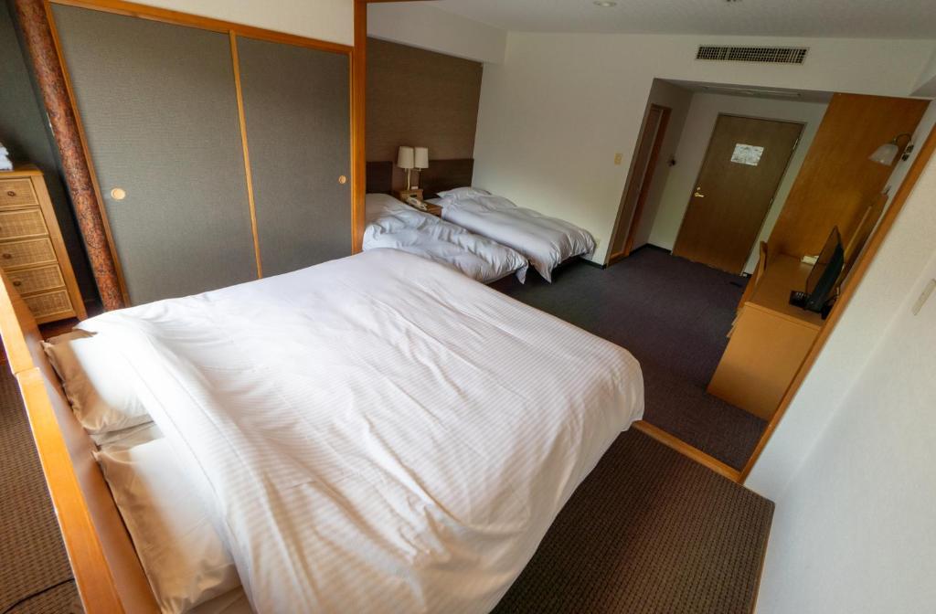 Postel nebo postele na pokoji v ubytování Hakuba Panorama Hotel