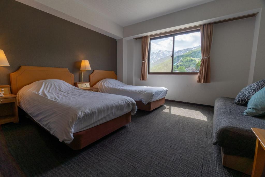 Postel nebo postele na pokoji v ubytování Hakuba Panorama Hotel