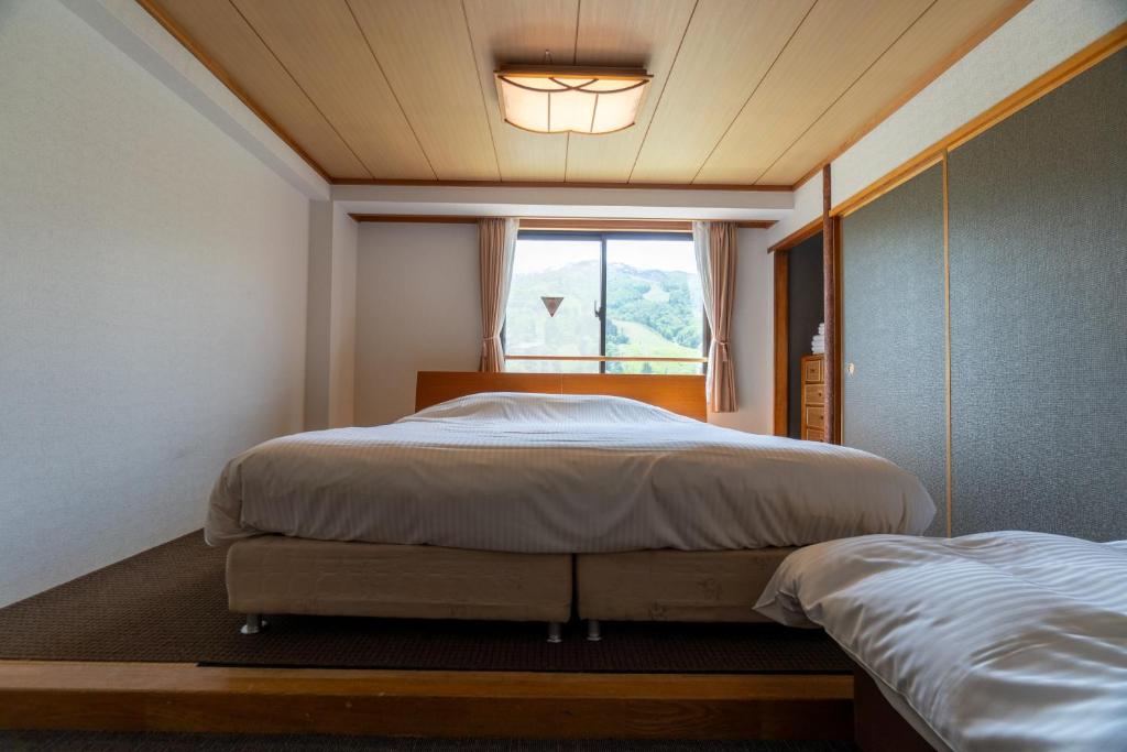 Postel nebo postele na pokoji v ubytování Hakuba Panorama Hotel