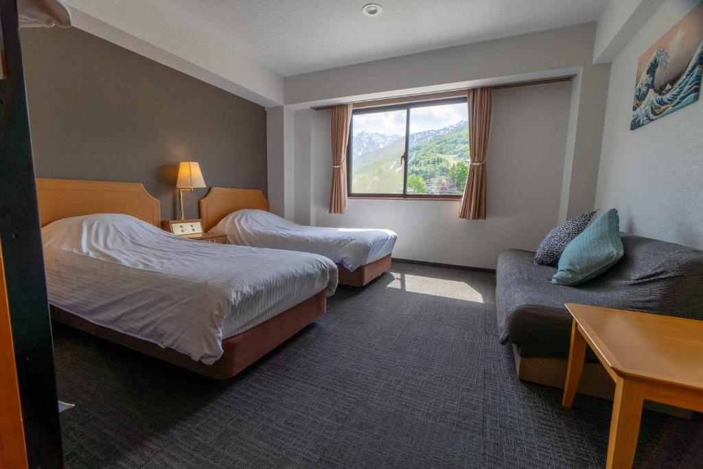 Postel nebo postele na pokoji v ubytování Hakuba Panorama Hotel