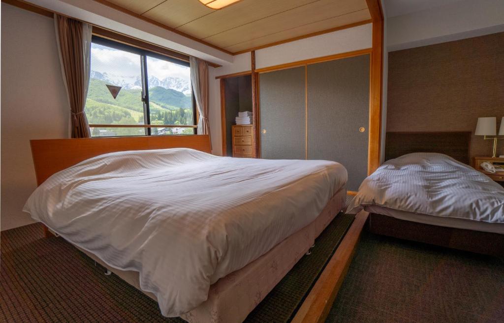Postel nebo postele na pokoji v ubytování Hakuba Panorama Hotel
