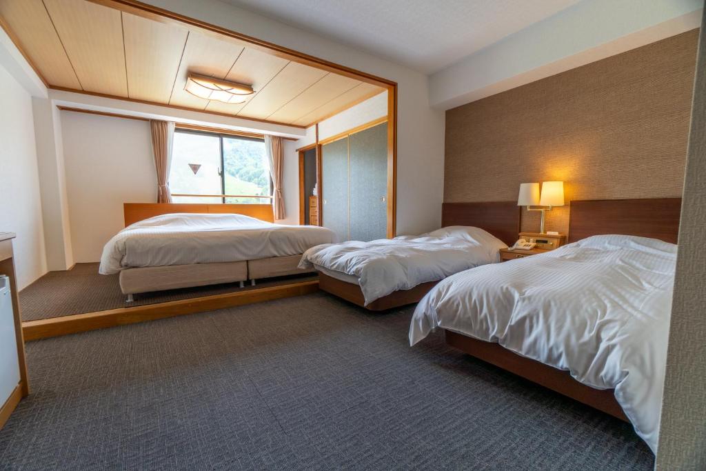 Postel nebo postele na pokoji v ubytování Hakuba Panorama Hotel