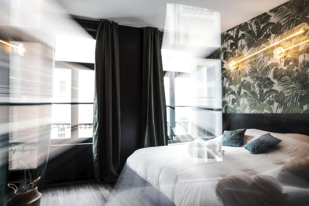 - une chambre avec un lit et une grande fenêtre dans l'établissement Secret Walls, à Bruxelles