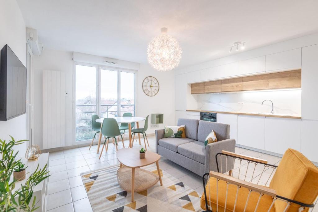 ein Wohnzimmer mit einem Sofa und einem Tisch in der Unterkunft Superbe T2 gare Annemasse avec Garage et balcon in Ville-la-Grand
