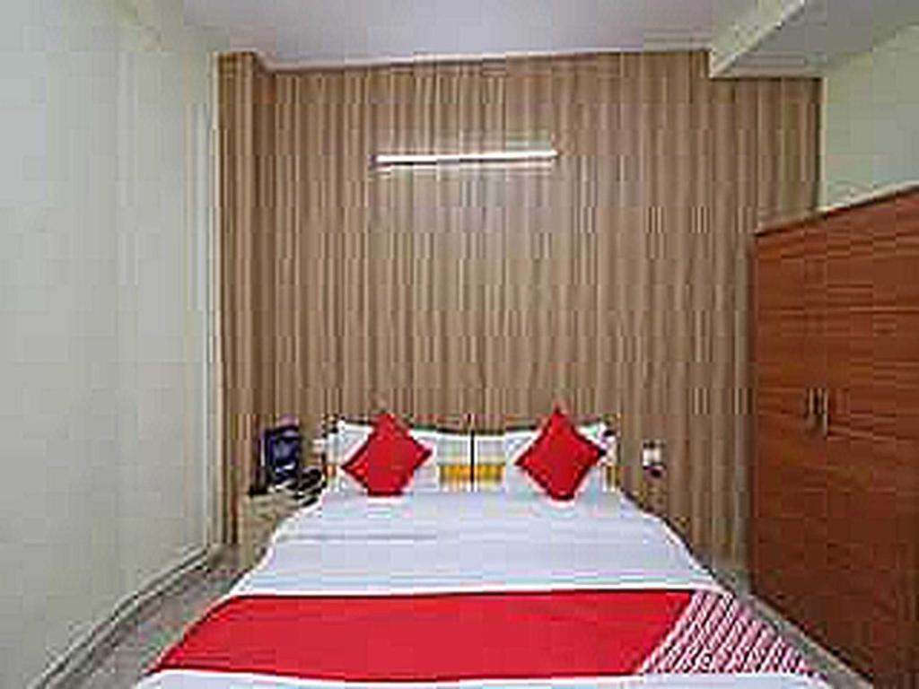 a bedroom with a large bed with red pillows at OYO Flagship 81283 Sukhsagar in Gurgaon