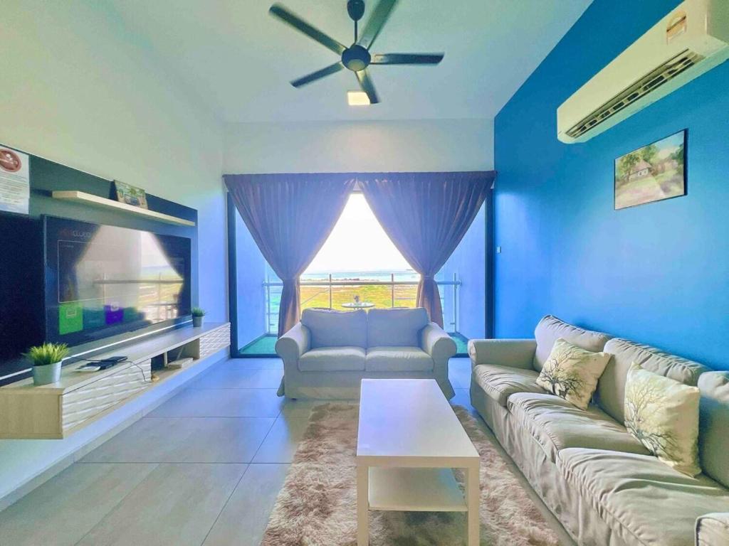 uma sala de estar com um sofá e uma televisão em Atlantis Residences Melaka em Malaca