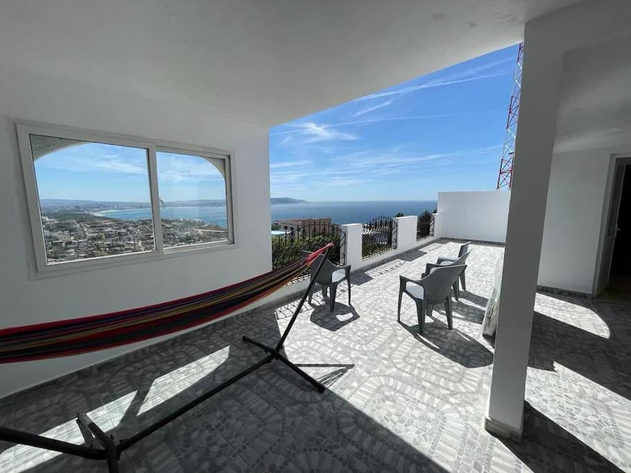 Un balcón con hamaca y vista al mar. en La villa des deux mers, en Tánger