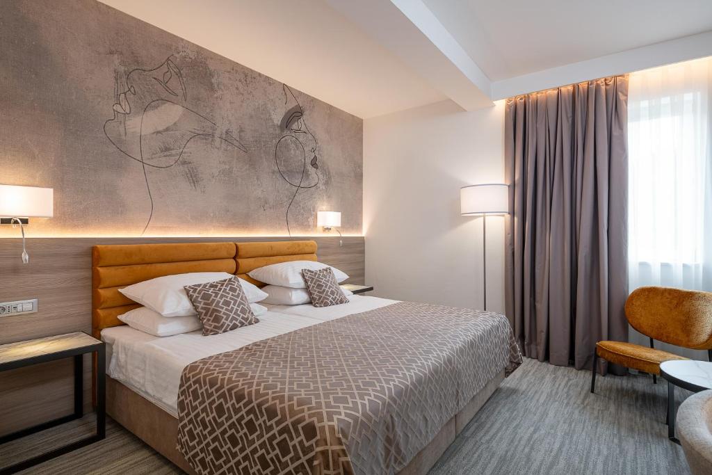 a hotel room with a bed and a painting on the wall at Hotel Ivka in Dubrovnik
