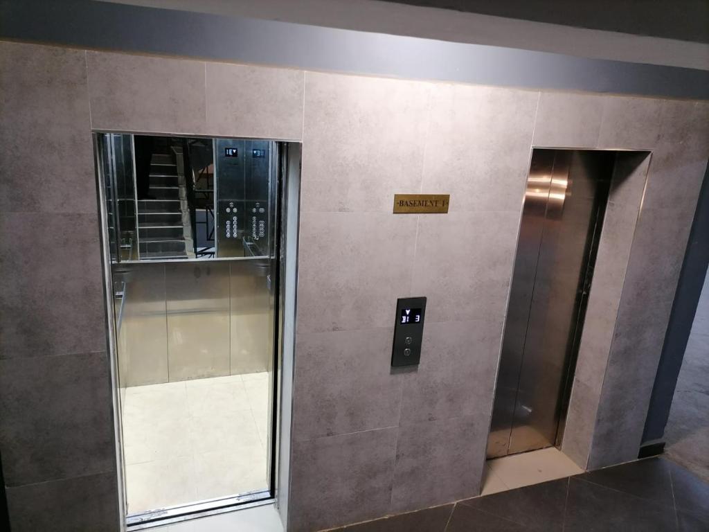 two elevators in a building with a sign on the wall at Alpha homes in Nakuru