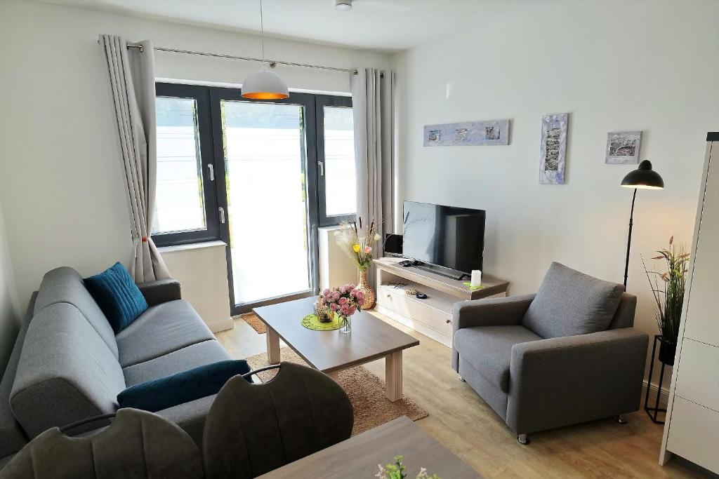 un salon avec un canapé et une télévision dans l'établissement Sonnendeck No 11 - Aurora Vista - ABC533 - nur Feriengäste!, à Hohen Wieschendorf